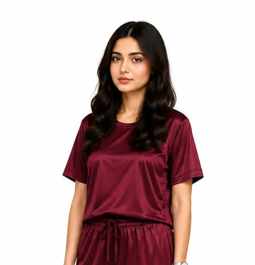 Woman wearing a maroon pajama set on a white background